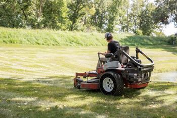 Lawn care crew mowing grass on a riding mower